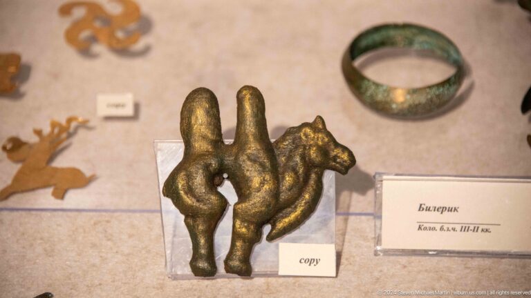Small bronze animal figure and green bracelet.