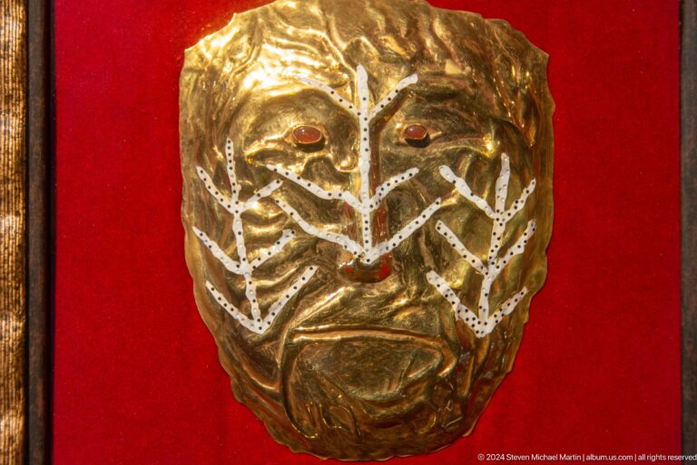 Close-up of embossed gold face motif.