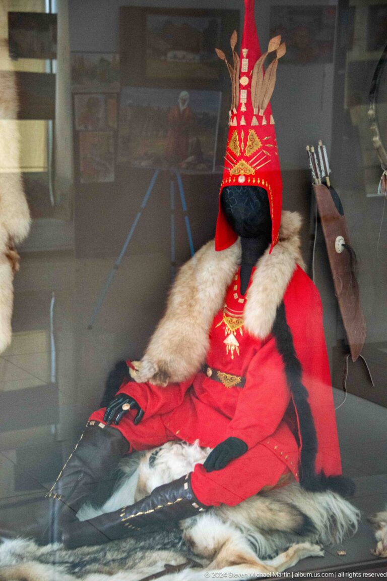 Mannequin in red robe and fur-trimmed headdress.
