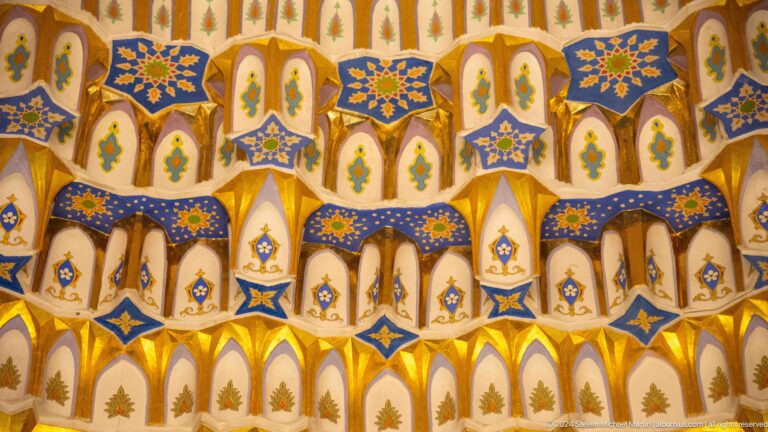 Blue star rosettes and white pointed cells in a gold field.