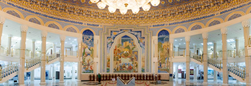 Symmetrical hall centered on mural beneath ornate dome.