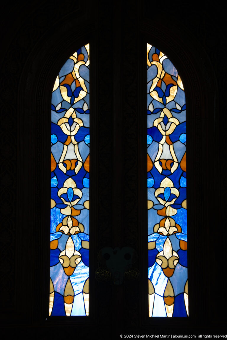 Two narrow blue floral panels separated by dark wood.