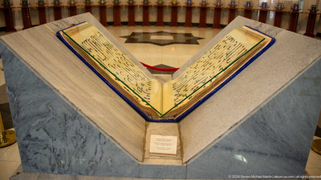 Open book with dark script, colored borders, and label below.