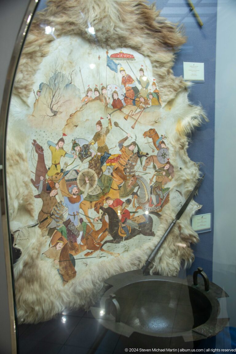 Mounted warriors and infantry painted on an irregular hide.