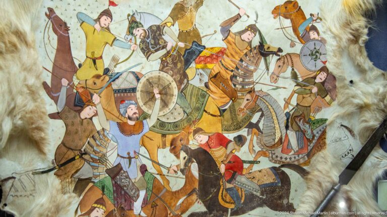 Overlapping mounted warriors and horses on pale hide.
