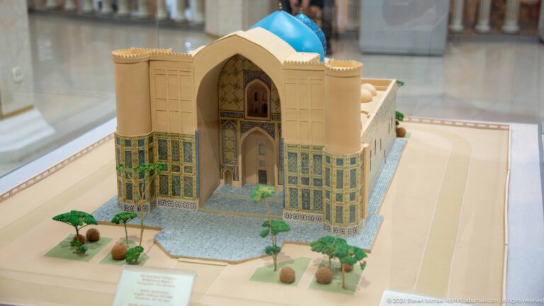Tiled entrance facade and turquoise dome in a landscaped model.