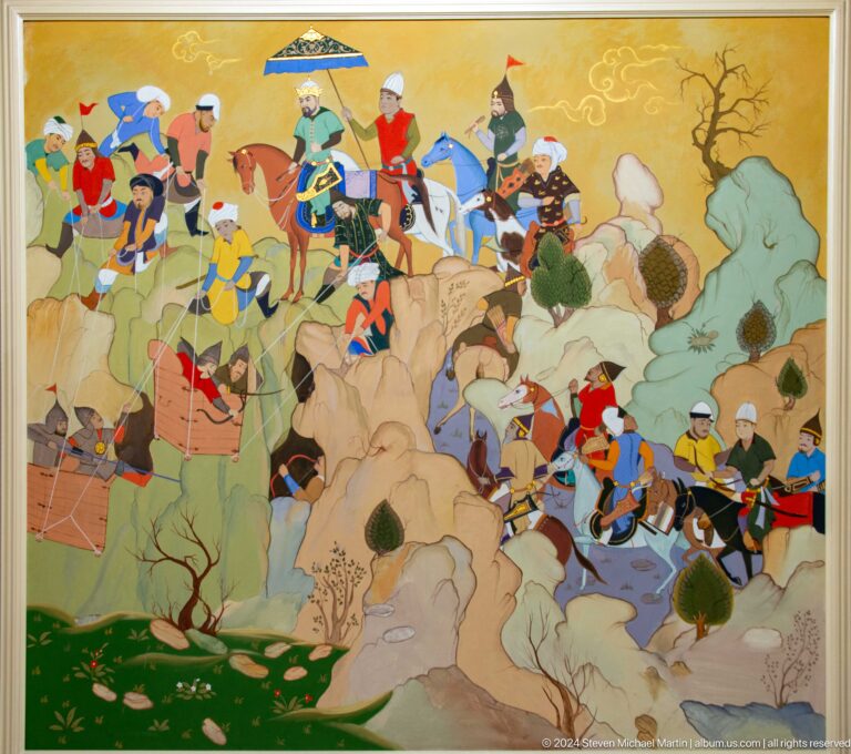 Riders, pack animals, and attendants descend a mountain path.