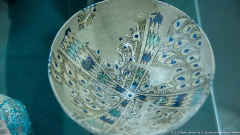 Round pale bowl painted with a stylized blue bird.