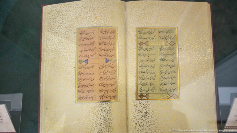 Two calligraphic blocks centered on a pale gold-flecked spread.