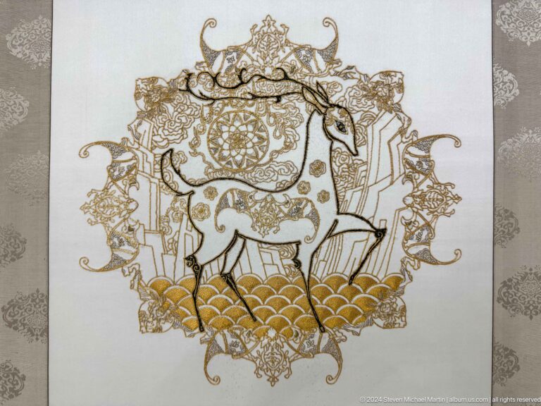 Two horned animals facing inward around a central rosette.