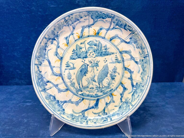 Round pale dish with two birds and segmented blue border.