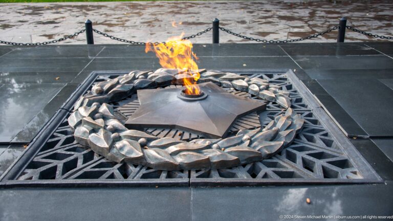Eternal flame burning in a star-shaped metal burner surrounded by a wreath at a war memorial in Almaty, Kazakhstan.