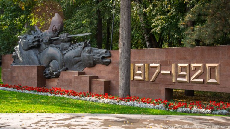 Stone memorial wall in Almaty with the dates 1917–1922 and a carved human figure in relief.