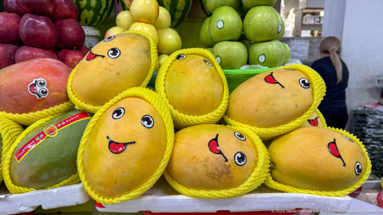 Melons decorated with cartoon faces arranged in a market display in Almaty, Kazakhstan.