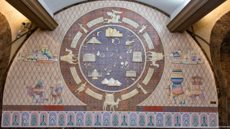 Large circular Kazakh cosmological mural in Almaty divided into symbolic sectors with zodiac-like cultural motifs.
