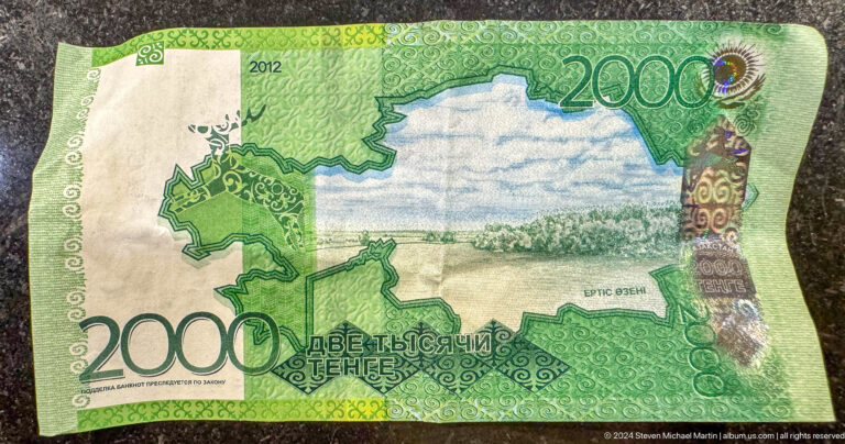 Kazakhstan 2000 tenge banknote showing a graphic lake landscape design laid flat for viewing.