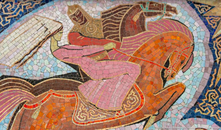 Close-up of a Soviet-era mosaic showing a reclining human figure composed of colorful tiles.