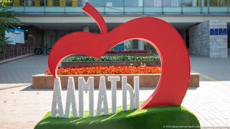 Red heart-shaped I Love Almaty sculpture standing as a city landmark.