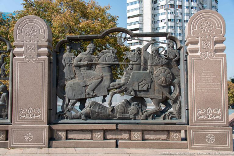 Ornate Kazakh-style metal fence panel featuring decorative animal relief in Almaty, Kazakhstan.