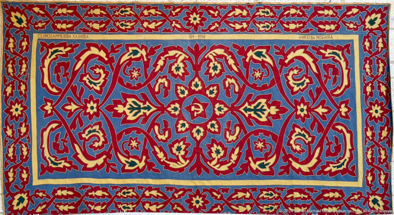 Close-up of a blue, red, and gold ornamental carpet detail on exhibition at the Central State Museum in Almaty, Kazakhstan.