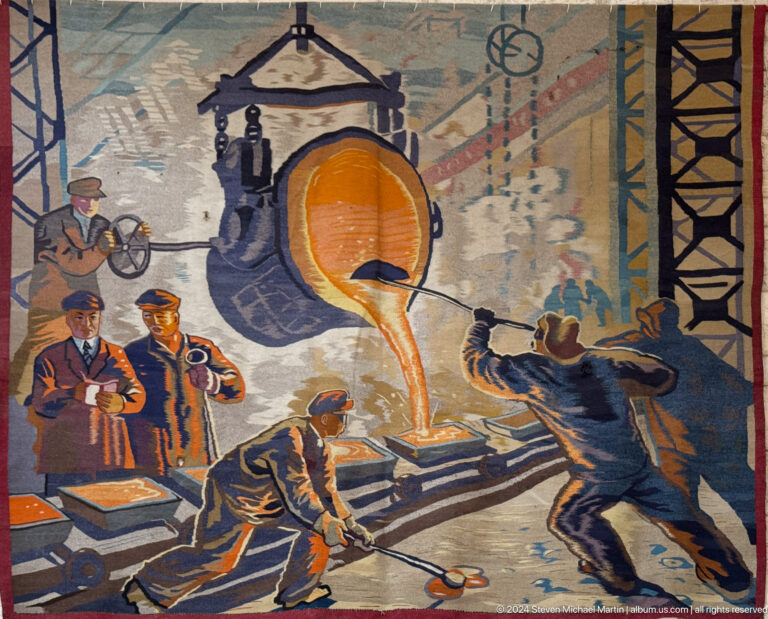 Medium view of an industrial-era mural in a museum, showing workers handling molten metal in a factory setting.