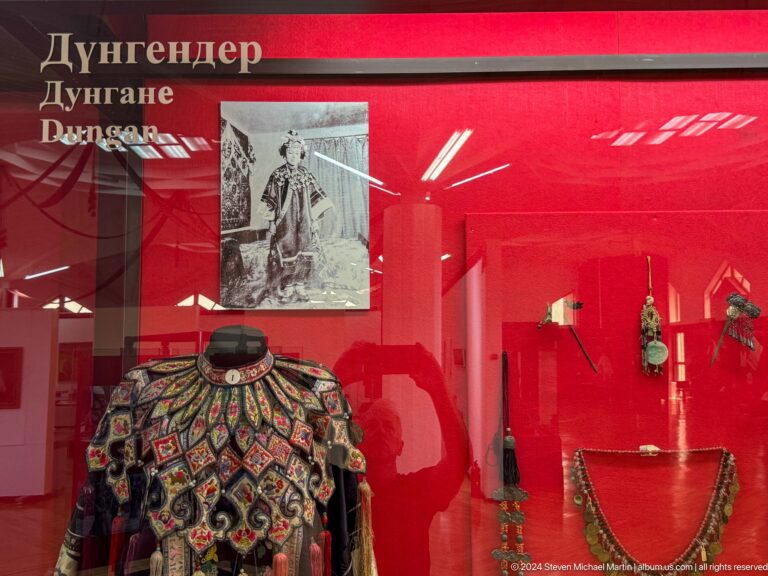 Medium view of a decorative vessel displayed in a red museum case at the Central State Museum in Almaty, Kazakhstan.