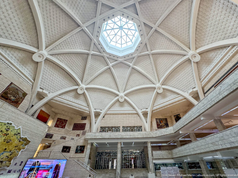 Wide view looking up at the ribbed geometric atrium ceiling and central skylight in the Central State Museum of Kazakhstan in Almaty.