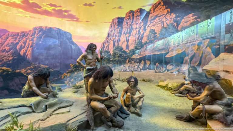 Museum diorama of prehistoric hunters and a camp beneath rocky cliffs in the Central State Museum of Kazakhstan in Almaty.