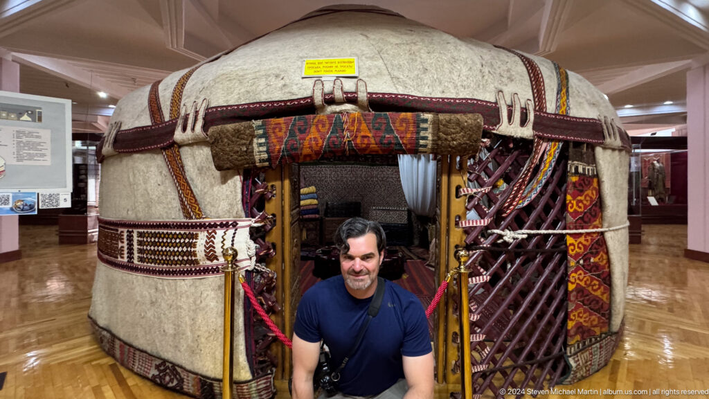 Visitor standing in the doorway of a reconstructed yurt inside the Central State Museum of Kazakhstan in Almaty.