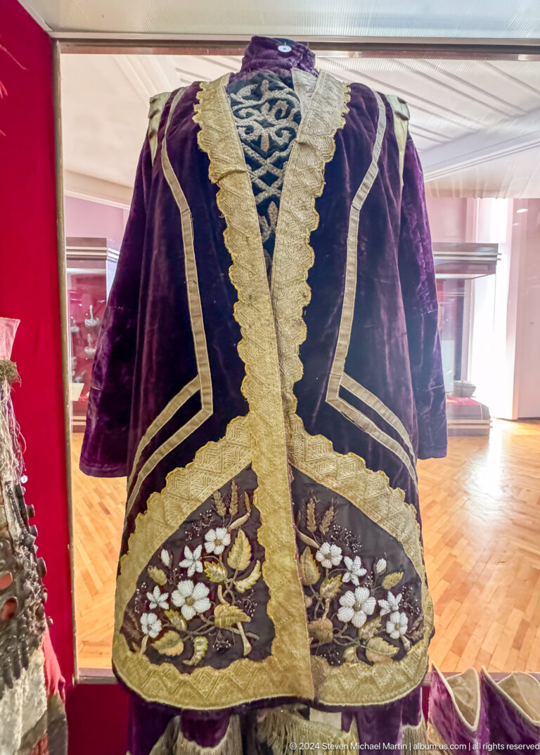 Dark velvet ceremonial robe with broad gold embroidery on display at the Central State Museum of Kazakhstan in Almaty.