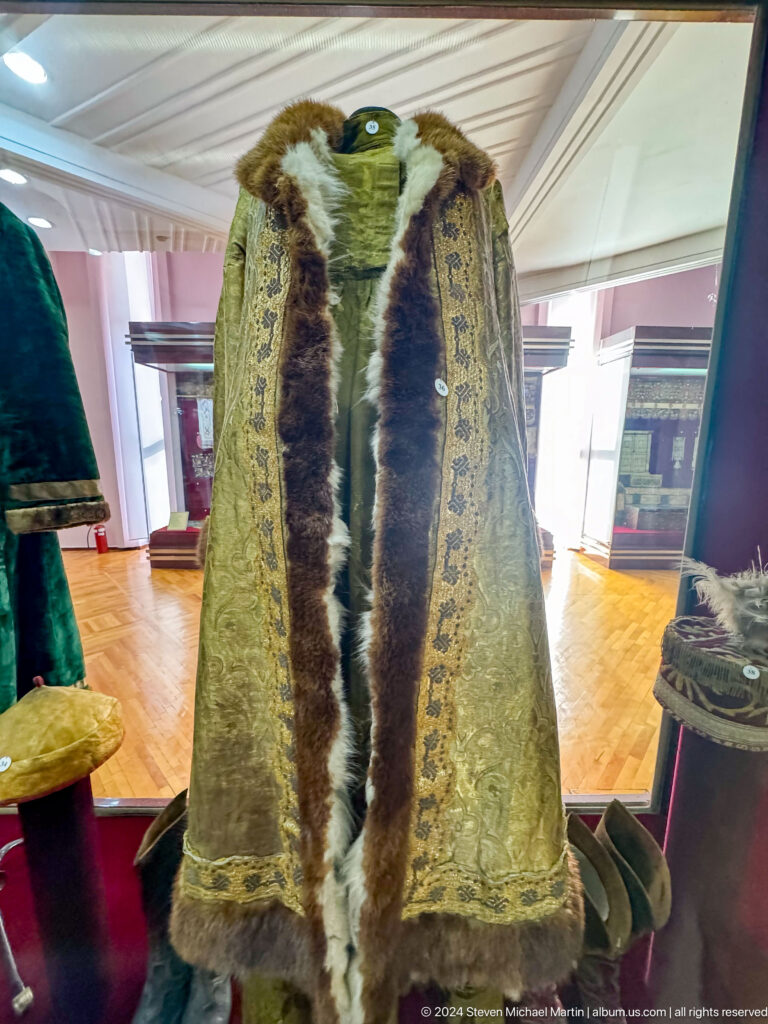 Long fur-lined traditional coat with patterned outer fabric exhibited at the Central State Museum of Kazakhstan in Almaty.