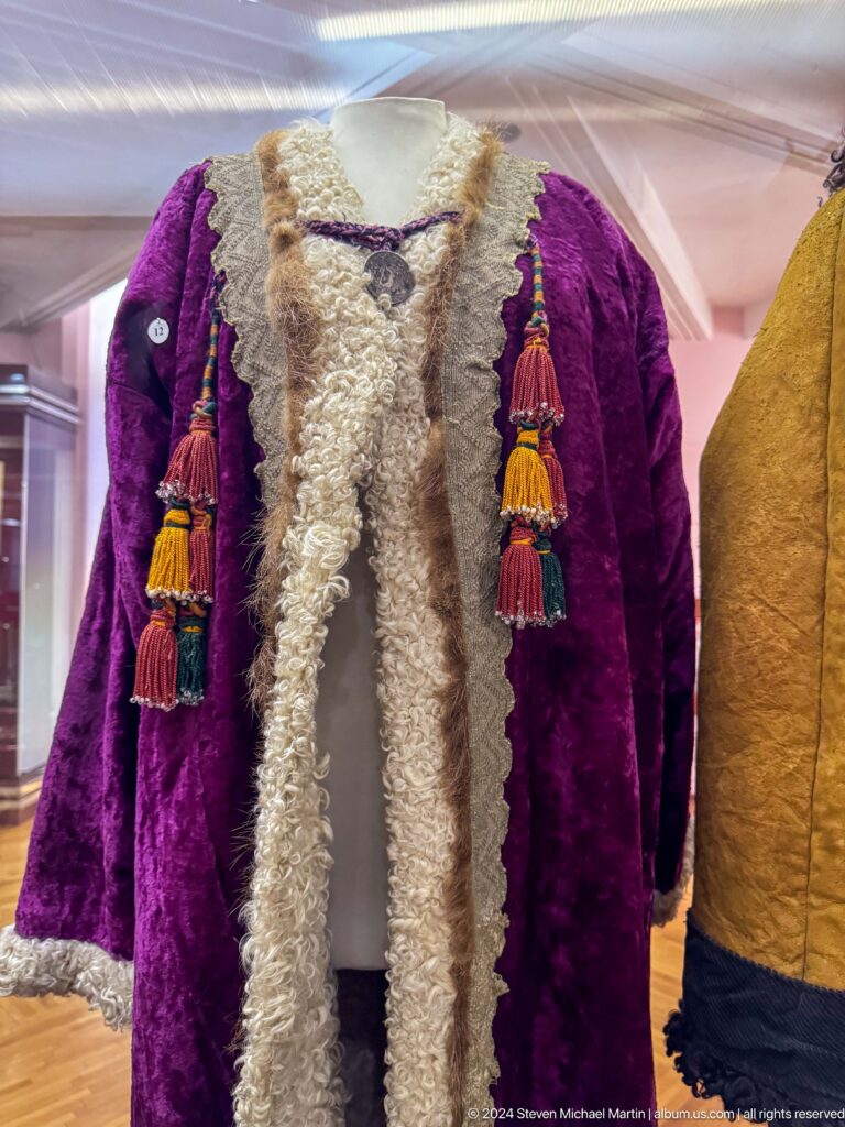 Purple velvet ceremonial coat with white fur trim and tassels on display in the Central State Museum of Kazakhstan in Almaty.