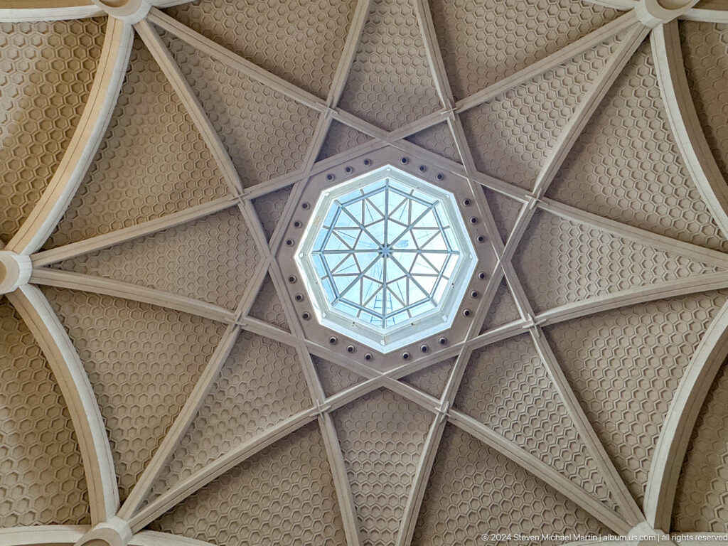 Upward view of a patterned atrium dome with a circular glass skylight at the center in the Central State Museum of Kazakhstan.
