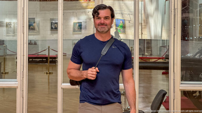 Male museum visitor posing in front of display cases at the Central State Museum of Kazakhstan in Almaty.