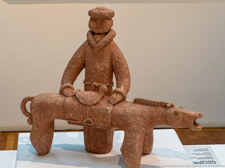 Terracotta rider on elongated animal.