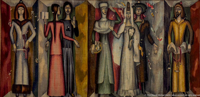 Group of tall robed figures in dark interior.