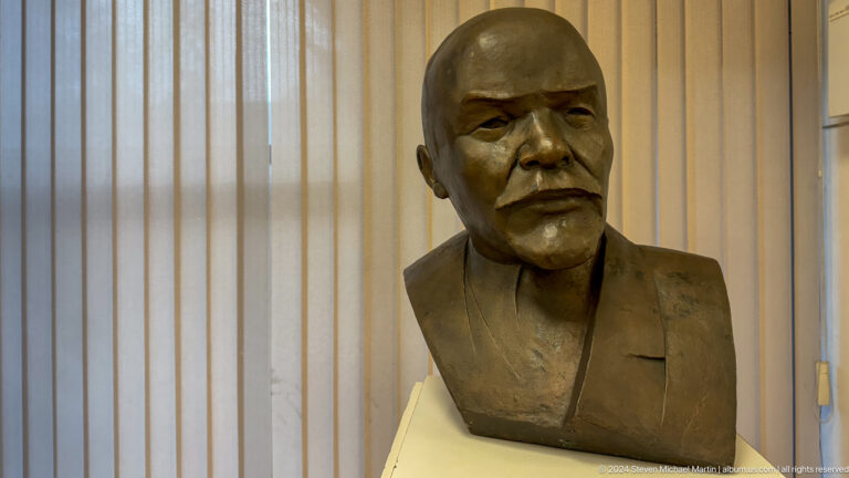 Bronze bust of bald bearded man.
