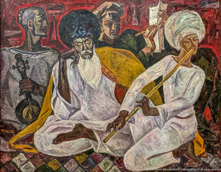 Seated Central Asian men in white robes.