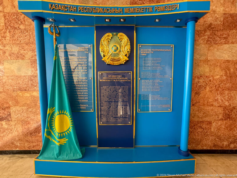 Blue museum information display with flags.