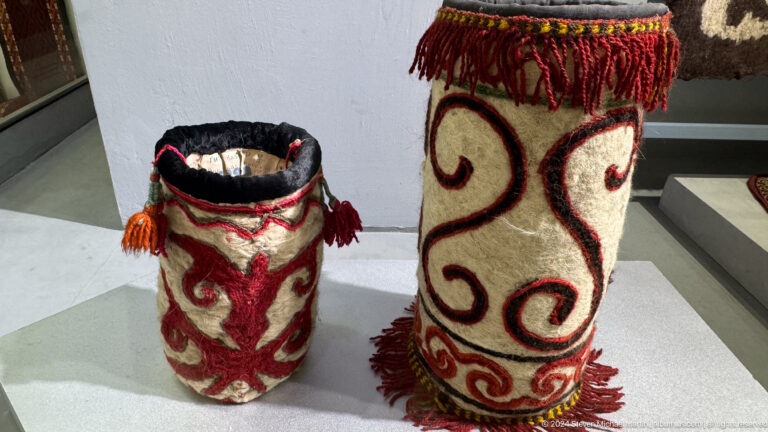 Two felt vessels with red scroll motifs.