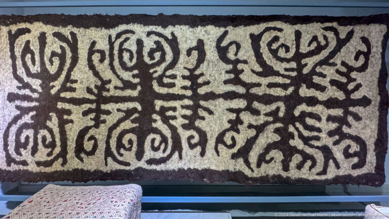 Black and white felt panel with scrolling pattern.