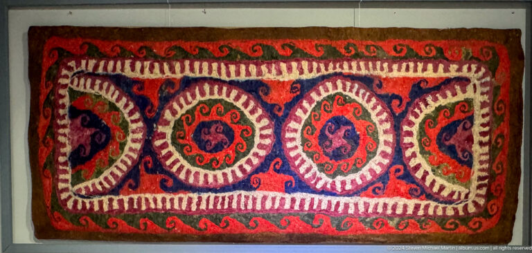 Long embroidered textile with circular medallions.