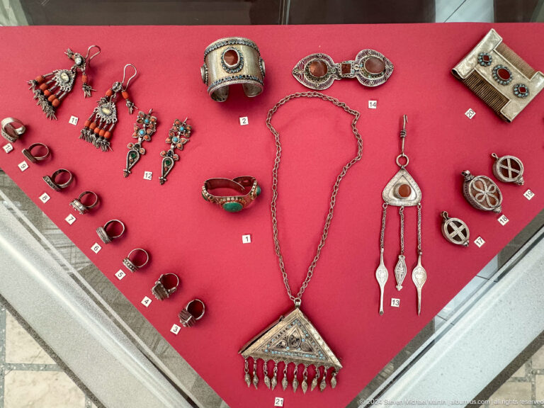 Assorted silver jewelry in display case.