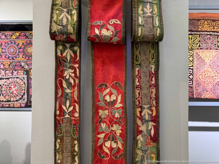 Group of long embroidered bands in a display.