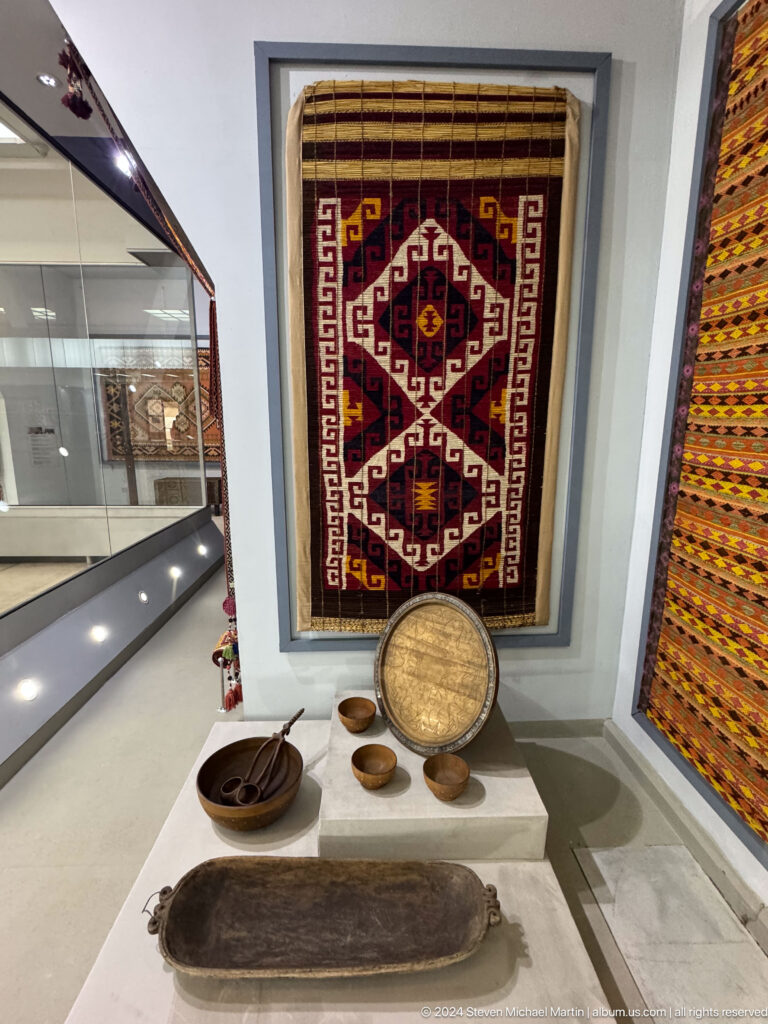 Small red geometric rug above round woven basket.