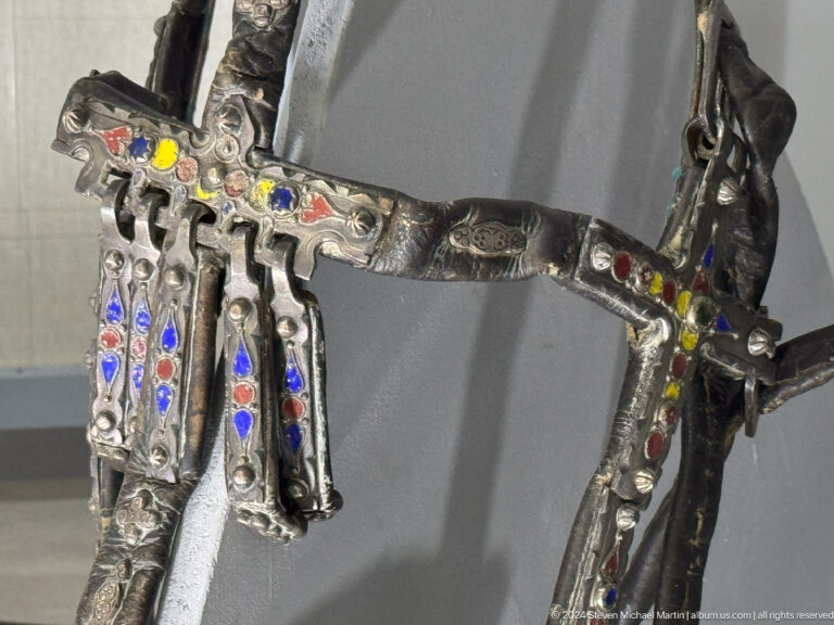 Ornamented metal horse tack with pendants.