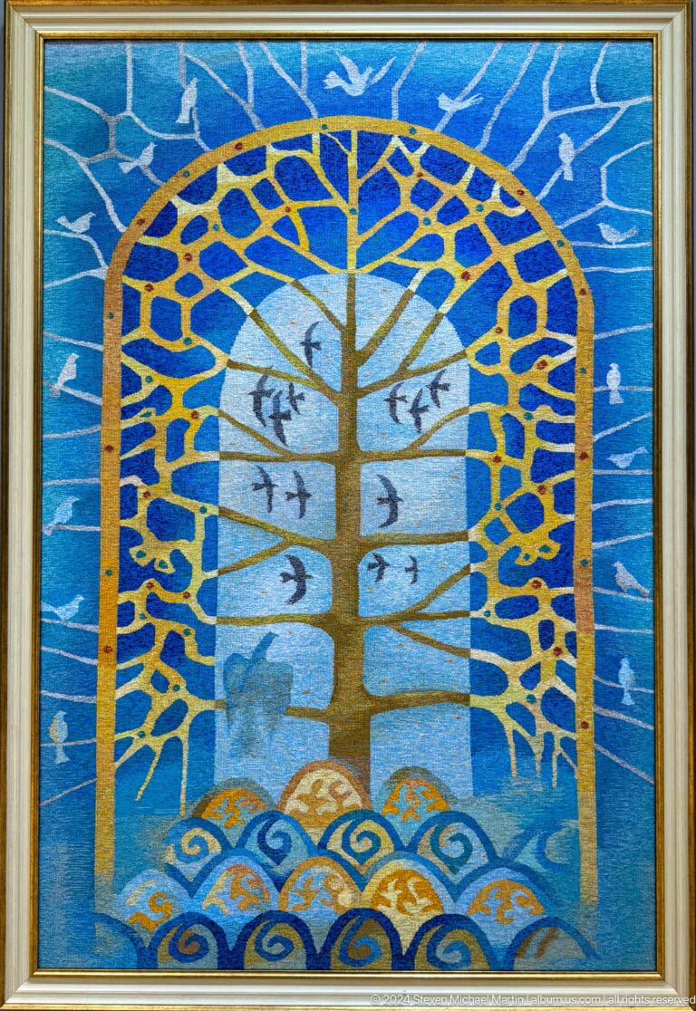 Blue textile with stylized tree and birds.
