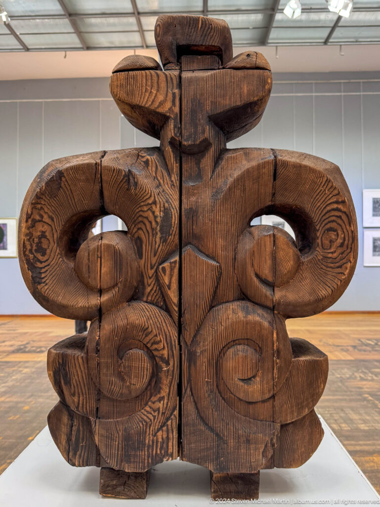 Paired carved wooden spiral forms.
