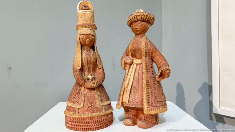 Two small carved wooden costumed figures.