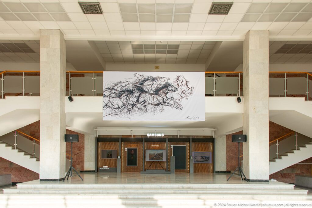 Museum atrium with monumental drawing above doors.